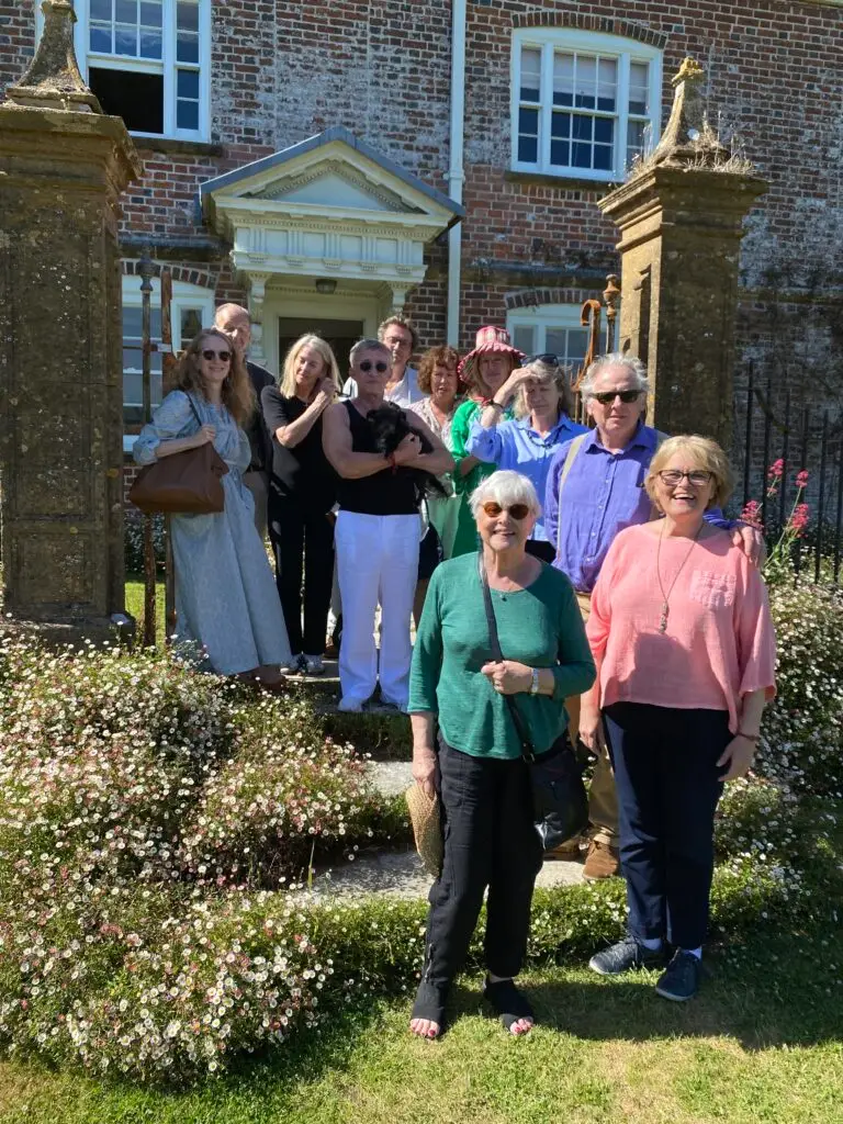 Happy group of English garden visitors standing on the steps